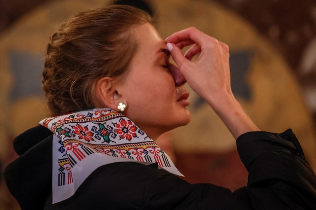 A believer cries while praying during a service in the Volodymyrsky Cathedral on Orthodox Easter, amid Russia's attack on Ukraine, in Kyiv, Ukraine on April 16, 2023. (Photo by Alina Yarysh/Reuters)