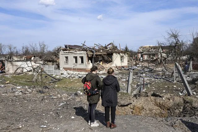 Women look at houses damaged by shelling in Chernihiv, Ukraine, Thursday, April 7, 2022. Ukraine is telling residents of its industrial heartland to leave while they still can after Russian forces withdrew from the shattered outskirts of Kyiv to regroup for an offensive in the country's east. (Photo by Evgeniy Maloletka/AP Photo)