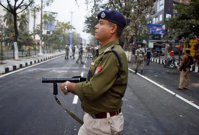 A police officer holds a tear gas gun during a protest against Citizenship Amendment Bill (CAB), a bill that seeks to give citizenship to religious minorities persecuted in neighbouring Muslim countries, in Guwahati, December 10, 2019. (Photo by Anuwar Hazarika/Reuters)