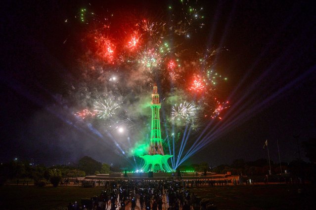 People watch fireworks explode overnight at the Minar-e-Pakistan national monument, on the eve of Pakistan’s independence day, in Lahore on August 13, 2024. (Photo by Syed Murtaza/AFP Photo)