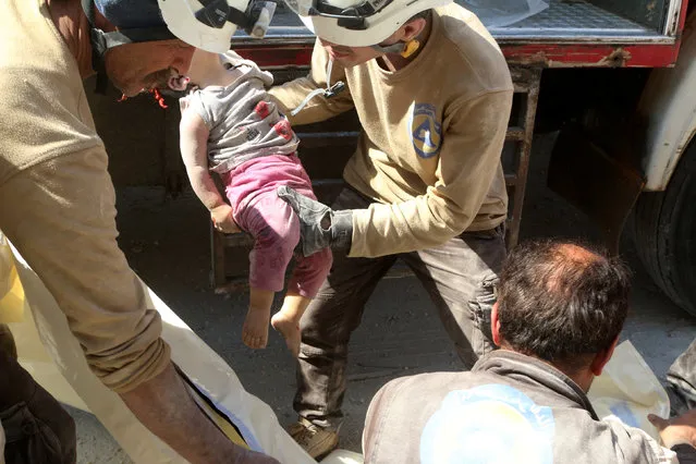 Civil defence members carry the dead body of a girl at a site hit by an airstrike in the rebel held area of Aleppo's al-Marjeh neighborhood, Syria, June 6, 2016. (Photo by Abdalrhman Ismail/Reuters)