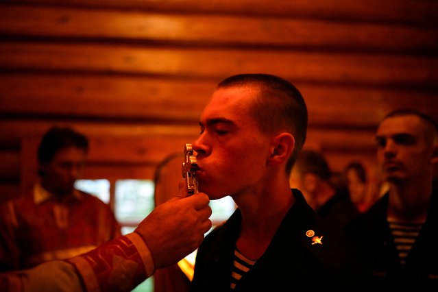 A Russian paratrooper kisses a cross during a religion service at the Church of Prophet Elijah at the 45th Special Forces Regiment of the Russian Airborne Forces in Sokolniki during celebrating the Day of paratroopers in Moscow, Russia, on Friday, August 2, 2024. Russian Paratroopers' Forces celebrate the 94th anniversary of the establishment of Russia's airborne forces. Elijah the Prophet is considered the heavenly patron of the Airborne Forces. (Photo by Alexander Zemlianichenko/AP Photo)