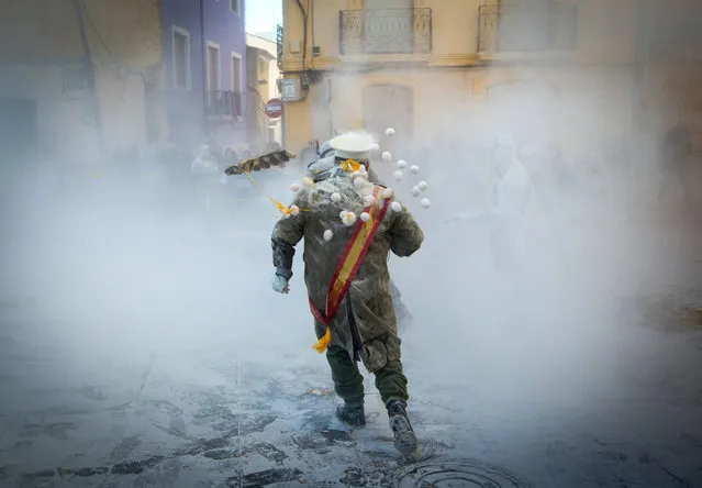 Revellers dressed in mock military garb throw eggs as they take part in the “Els Enfarinats” battle in the southeastern Spanish town of Ibi on December 28, 2019. (Photo by Jaime Reina/AFP Photo)