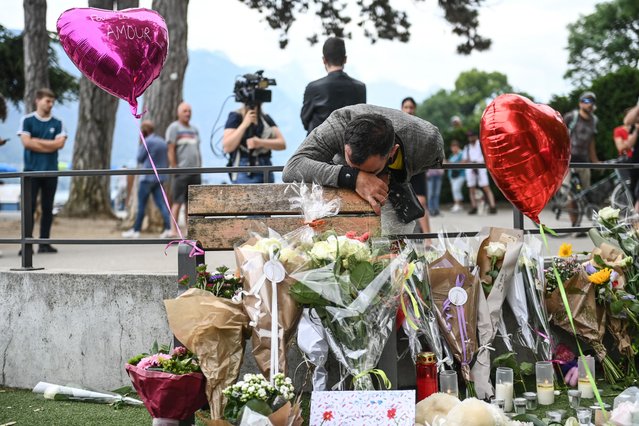 A man reacts in front of flowers and candles for the victims of a stabbing attack that occured the day before in the “Jardins de l'Europe” parc in Annecy, French Alps, on June 9, 2023. A man armed with a knife stabbed four preschool children and injured two adults by a lake in the French Alps on June 8 in an attack that sent shock waves through the country. The suspect is a Syrian in his early 30s who was granted refugee status in Sweden in April, a police source told AFP. He was arrested at the scene. (Photo by Olivier Chassignole/AFP Photo)