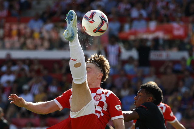 Girona's Viktor Tsygankov, left, challenges for the ball with Barcelona's Alejandro Balde during the Spanish La Liga soccer match between Girona and Barcelona at the Montilivi stadium in Girona, Spain, Sunday, September 15, 2024. (Photo by Joan Monfort/AP Photo)