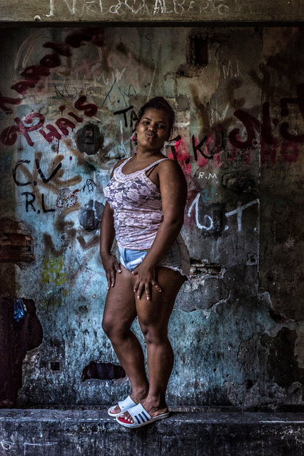 A resident stands in front of an elevator shaft covered in graffiti at the building. Like other favelas, Mangueira lacks proper sanitation, education, security and healthcare services. (Photo by Tariq Zaidi/The Guardian)