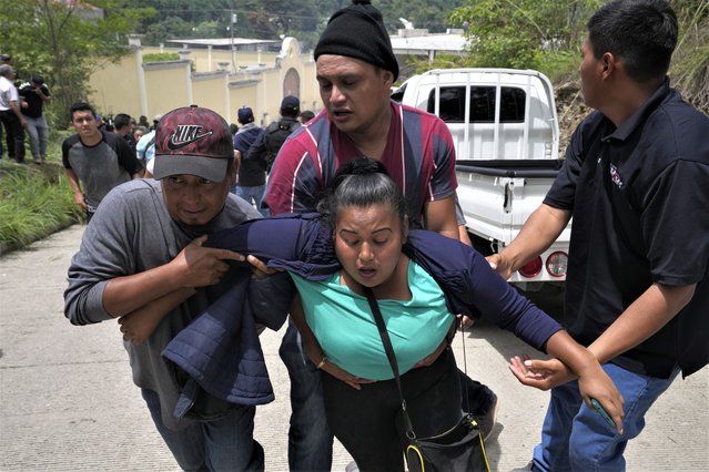 Voters aid a woman affected by tear gas fired by police at a polling station after clashes erupted when electoral authorities delayed opening it to voters due to alleged electoral violations during general elections in San Jose El Golfo, outskirts of Guatemala City, Sunday, June 25, 2023. (Photo by Moises Castillo/AP Photo)