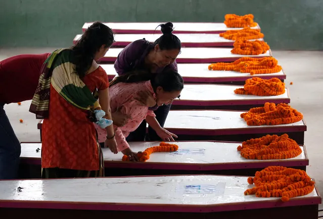 Family members cry near coffins containing the bodies of Nepali nationals, who were killed when a suicide bomber struck a minibus in Kabul, lined up after being flown from Afghanistan at Tribhuvan International Airport in Kathmandu, Nepal June 22, 2016. (Photo by Navesh Chitrakar/Reuters)