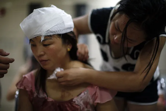 An injured woman is treated inside a hospital following explosions in northeastern China's Tianjin municipality, Thursday, August 13, 2015. (Photo by Chinatopix Via AP Photo)