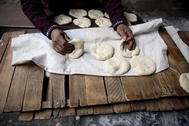 Baker Eulogio Pillco bakes traditional bread using an oven made of clay in the town of Pisac, Cusco, August 13, 2015. (Photo by Pilar Olivares/Reuters)