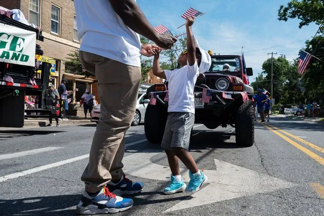 Baron Freeman, 2, looks up at his father Ed Freeman before the 2022 4th of July Parade in Takoma Park, MD on July 04, 2022. (Photo by Craig Hudson for The Washington Post)