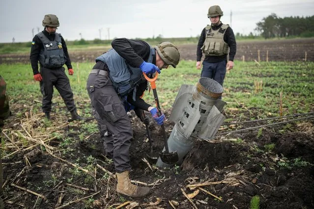 Bomb disposal experts from the Ukrainian State Emergency Service make safe a Russian BM-30 Smerch rocket and remove it from a field on May 31, 2022 in Borodianka, Ukraine. The demining and clearing of unexploded ordnance in Ukraine after the Russian invasion could take between 5-7 years, in the Kyiv region alone they have already removed over 36,000 items of dangerous ordnance. (Photo by Christopher Furlong/Getty Images)