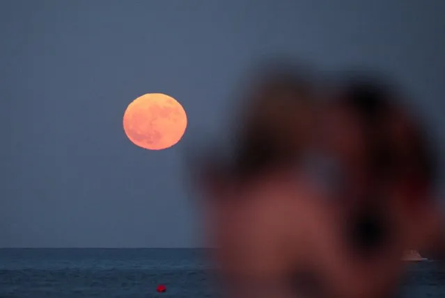 A full moon known as the “Buck Moon” rises in Larnaca, Cyprus on July 13, 2022. (Photo by Yiannis Kourtoglou/Reuters)