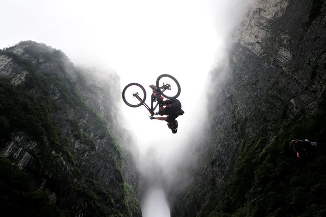 A contestant performs a stunt on a bicycle during a competition in Zhangjiajie, Hunan province, China, July 16, 2016. (Photo by Reuters/Stringer)