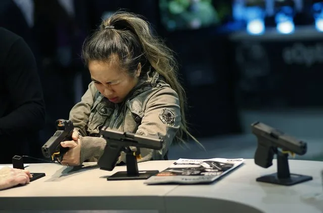 In this January 19, 2016 file photo, a woman looks at a handgun at the Glock booth at the Shooting Hunting and Outdoor Trade Show in Las Vegas. Nearly two-thirds of Americans expressed support for stricter gun laws, according to an Associated Press-GfK poll released Saturday, July 23, 2016. A majority of poll respondents oppose banning handguns. (Photo by John Locher/AP Photo)