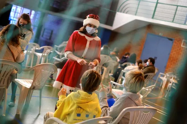 A person dressed in a Santa costume entertains children at the Ajuda vaccination centre as Portugal begins the coronavirus disease (COVID-19) vaccination of 5 to 11 year-olds, in Lisbon, Portugal, December 18, 2021. (Photo by Pedro Nunes/Reuters)