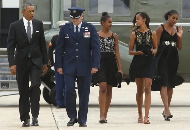U.S. President Barack Obama (L-R) is escorted by U.S. Air Force Colonel John Millard as Obama, his daughters Sasha and Malia and first lady Michelle Obama arrive to board Air Force One at Joint Base Andrews, Maryland August 30, 2014. Obama is visiting New York on Saturday to attend a personal event. (Photo by Jonathan Ernst/Reuters)