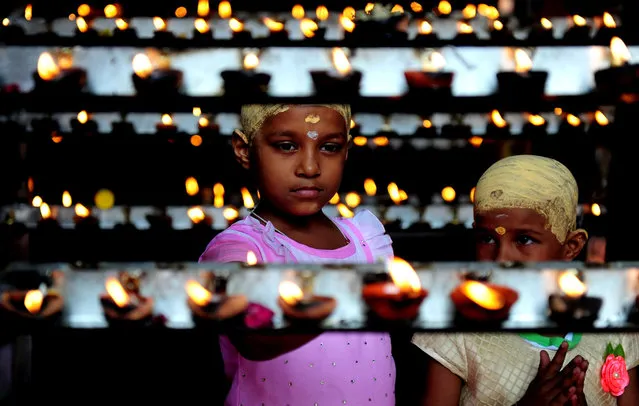 Indian Hindu devotees light candles during “Aadi Kiruthigai” celebrations at Vadapazhni Murugan temple in Chennai on July 28, 2016. Aadi is considered a holy month by Tamils and is celebrated with rituals worshipping Hindu gods. (Photo by Arun Sankar/AFP Photo)