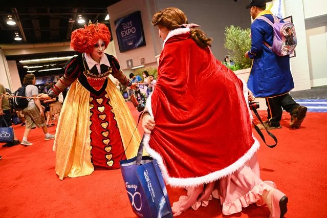 A fan cosplaying as the Queen of Hearts from Alice in Wonderland reacts to Belle in costume during the Walt Disney D23 Expo in Anaheim, California on September 9, 2022 (Photo by Patrick T. Fallon/AFP Photo)