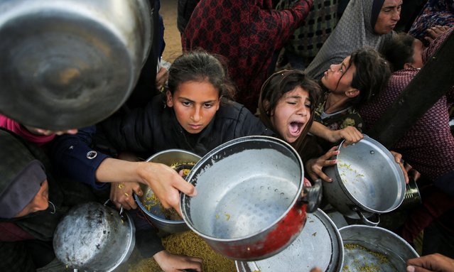 Palestinians gather to receive food cooked by a charity kitchen, before a ceasefire between Hamas and Israel takes effect, in Khan Younis, in the southern Gaza Strip, on January 17, 2025. (Photo by Hatem Khaled/Reuters)