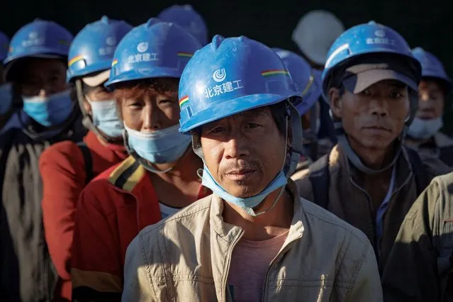 Workers gather to begin their shift at the construction site of the new Workers' Stadium in Beijing, China on September 23, 2022. (Photo by Thomas Peter/Reuters)