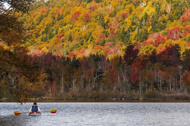 A kayaker paddles in Echo Lake while surrounded by the fall foliage colors in Franconia Notch State Park in Franconia, New Hampshire, USA, 03 October 2024. The peak foliage season is beginning in New England. (Photo by Cj Gunther/EPA/EFE)