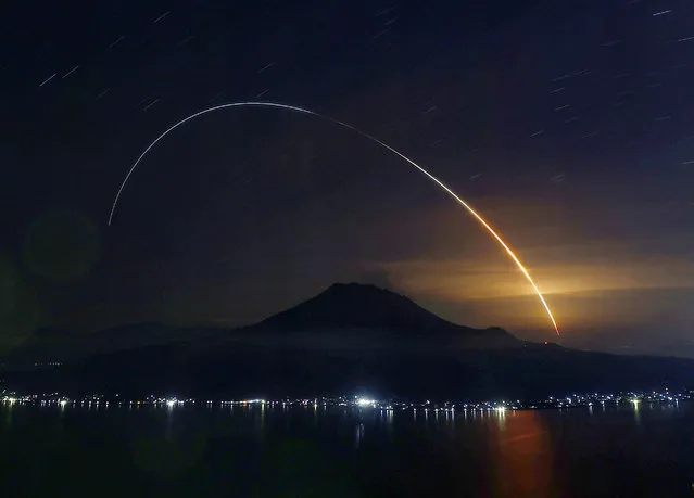 A photo shows a light trail of rocket carrying H-II Transfer Vehicle seen from a launch pad over Mt. Sakurajima at the Japan Aerospace Exploration Agency (JAXA) Tanegashima Space Center in Tanegashima Island, Minamitane, Kagoshima prefecture on May 21, 2020. The Kounotori unmanned cargo vessel lifted off successfully and will dock at the International Space Station (ISS) to deliver food, experimental equipment on May 25. (Photo by The Yomiuri Shimbun via AP Images)