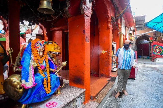 A worker disinfects the premises at Kalkaji temple ahead of its re-opening amid the lockdown, on June 6, 2020 in New Delhi, India. The Centre has issued a set of guidelines that need to be followed by the religious institutions in the wake of the coronavirus pandemic, to prevent the spread of the virus. Authorities at the Kalkaji shrine have said that they are taking necessary precautionary measures, and the devotees have been asked to avoid bringing any offerings. (Photo by Amal KS/Hindustan Times via Getty Images)