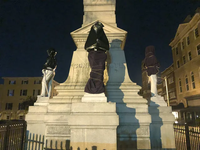 The Confederate monument is covered in sheets and bags in Downtown Portsmouth, Va., early Wednesday, June 10, 2020. Protesters covered the monument  with trash bags and sheets Wednesday, several hours after the city's council members had a meeting to figure out ways to relocate it. (Photo by Kiahnna Patterson/WAVY-TV 10 via AP Photo)