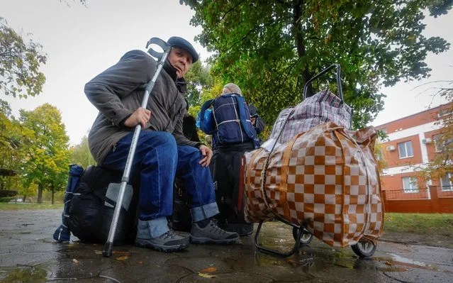 Civilians evacuated from the Russian-controlled city of Kherson wait to board a bus heading to Crimea, in the town of Oleshky, Kherson region, Russian-controlled Ukraine on October 23, 2022. (Photo by Alexander Ermochenko/Reuters)