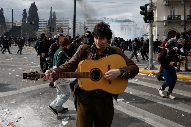 A man holds a guitar as demonstrators gather near the Greek parliament during a protest, marking the second anniversary of the country's worst railway disaster, while an investigation continues, in Athens, Greece, on February 28, 2025. (Photo by Louisa Gouliamaki/Reuters)