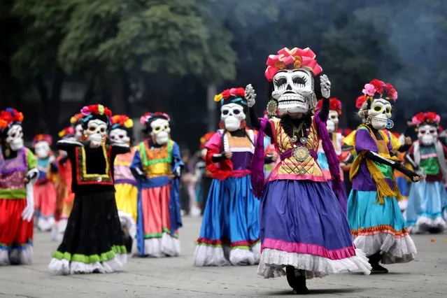 People in costumes participate in a parade for Day of the Dead celebrations, in Mexico City, Mexico, 29 October 2022. According to the tradition of the Day of the Dead, in which skeletons and skulls are customary, the dead return to the world of the living on the first and second days of November. (Photo by Sashenka Gutierrez/EPA/EFE)