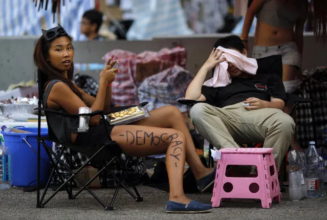 A protester sits under a tent as she helps to block an area around the government headquarters in Hong Kong October 6, 2014. (Photo by Carlos Barria/Reuters)