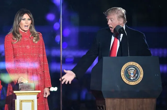 President Donald Trump (R) gestures as First lady Melania Trump smiles during the 95th annual National Christmas Tree Lighting ceremony at the Ellipse in President's Park near the White House in Washington on November 30, 2017. (Photo by Jim Watson/AFP Photo)