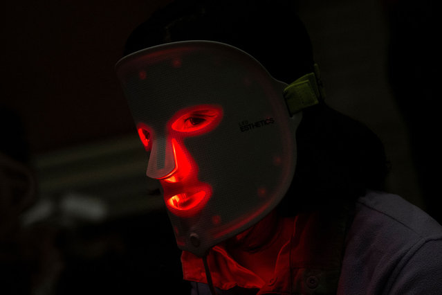A person wears a red light mask from Light Tree Ventures during Pepcom's Digital Experience at the The Mirage resort during the Consumer Electronics Show (CES) in Las Vegas, Nevada on January 8, 2024. (Photo by Brendan Smialowski/AFP Photo)