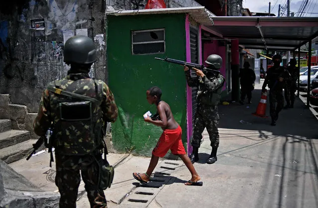 Brazilian Army soldiers patrol during a security operation at Mangueira favela, in Rio de Janeiro, Brazil on December 6, 2017. Brazilian police and soldiers captured one of Rio de Janeiro' s most wanted alleged drug trafficking bosses Wednesday in a rare high- profile success for the city' s beleaguered security forces. The arrest of the man known to most by his nickname “Rogerio 157” came after months of failed attempts. Nearly 3,000 police and troops were involved in the operation, the authorities said. (Photo by Carl de Souza/AFP Photo)