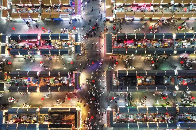 This aerial photo taken on June 16, 2020 shows people visiting a night market in Shenyang in China's northeastern Liaoning province. (Photo by AFP Photo/China Stringer Network)
