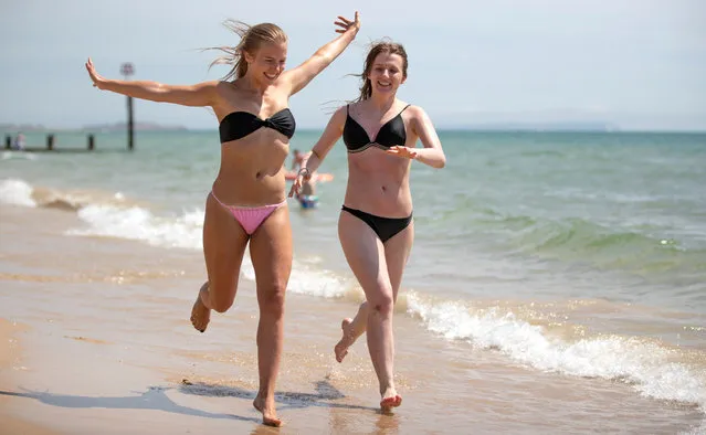 Ugne Jankauskaite, 22, and Roberta Sukyte, 20, playing in the surf in Bournemouth Beach in Dorset on July 18, 2020, as parts of the UK enjoy warm weather. (Photo by  Bournemouth News/The Sun)