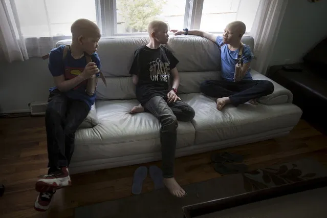 Mwigulu Matonage (L), Pendo Sengerema (C) and Emmanuel Festo (R) sit on a sofa. (Photo by Carlo Allegri/Reuters)