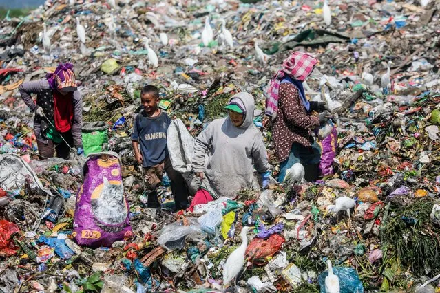 Scavengers collect plastic materials at a garbage dumpsite in Marelan, Medan, North Sumatra Province, Indonesia, 30 November 2022. According to a record by the Indonesian Environment Ministry, the country produced more than 30,8 million ton waste in 2021, which 17,6 percent was plastic waste. (Photo by Dedi Sinuhaji/EPA/EFE/Rex Features/Shutterstock)