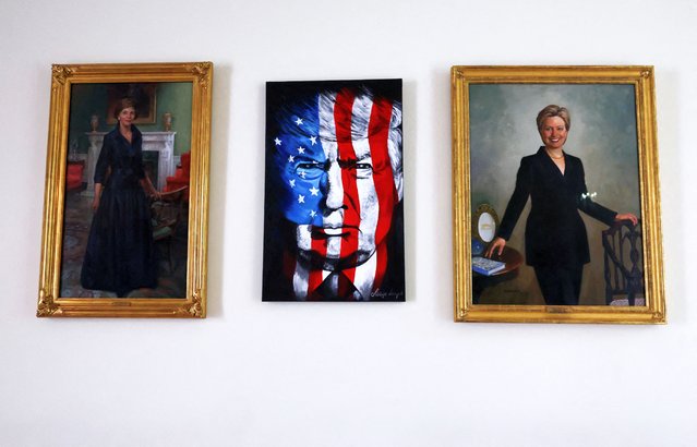 A portrait of U.S. President Donald Trump hangs between paintings of former first ladies Laura Bush and Hillary Clinton at the White House on May 20, 2025. (Photo by Kevin Lamarque/Reuters)