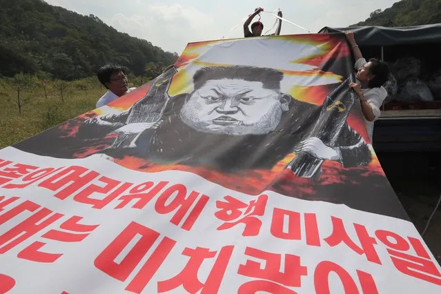 Anti-North Korea activists launch helium ballons in a field in Paju, near the demilitarized zone (DMZ) separating North and South Korea, on September 15, 2016.
South Korean activists launched tens of thousands of anti-Pyongyang leaflets across the border into North Korea, denouncing its latest nuclear test and defying threats of retaliation. (Photo by AFP Photo/Yonhap)
