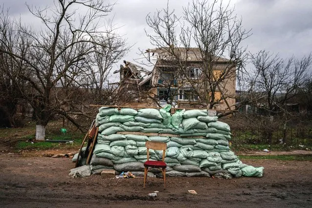 This photograph taken on December 30, 2022, shows a military sandbags wall in front of a destroyed house in the village of Davydiv Brid, in Kherson region, amid the Russian invasion of Ukraine. (Photo by Dimitar Dilkoff/AFP Photo)