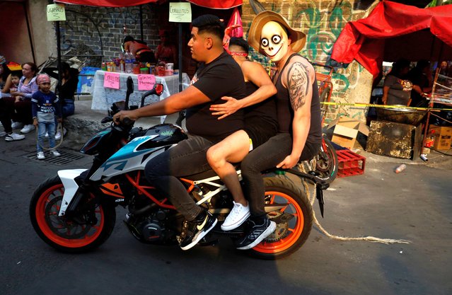 Members of Los Judas de Santo Domingo are riding aboard a motorcycle with residents of Pedregal de Santo Domingo in Mexico City on March 28, 2024, participating in a procession for the Holy Week celebrations. (Photo by Gerardo Vieyra/NurPhoto/Rex Features/Shutterstock)