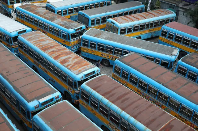 A man wearing a protective mask walks in between parked passenger buses after authorities announced a complete lockdown for two days this week in the West Bengal state, amidst the spread of coronavirus disease (COVID-19), in Kolkata, India, September 11, 2020. (Photo by Rupak De Chowdhuri/Reuters)