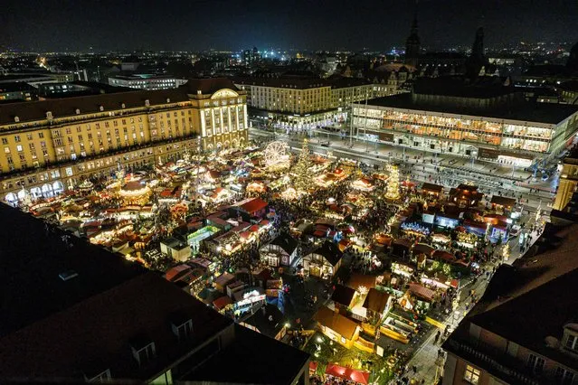 A general view taken on November 23, 2022 shows the Dresden Striezelmarkt during its opening in Dresden, eastern Germany. Every year, the Striezelmarkt attracts around three million visitors. The first Striezelmarkt took place in 1434 and this year it will be held for the 588th time, making it the oldest Christmas market in Germany. It will be open until December 24. Among the attractions is the 14,61 meter tall Erzgebirge (Ore Mountains) step pyramid and the reportedly world's largest walk-in Schwibbogen candle-holder. (Photo by Jens Schlueter/AFP Photo)