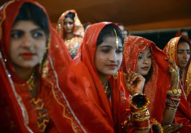 Pakistani brides attend a mass marriage ceremony in Karachi late March 26, 2013.  Some 110 couples participated in the mass wedding ceremony organised by a local charity welfare trust Al Ghousia. (Photo by Asif Hassan/AFP Photo)