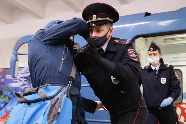 A police officer detains a passenger at Studencheskaya Station of the Novosibirsk Underground amid the COVID-19 pandemic in Novosibirsk, Russia on October 23, 2020. Perhaps the man was without a protective mask. (Photo by Kirill Kukhmar/TASS)