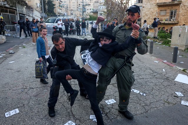 Police members detain an Ultra-Orthodox Jewish boy during a protest against attempts to change government policy that grants ultra-Orthodox Jews exemptions from military conscription, in Jerusalem on April 11, 2024. (Photo by Ronen Zvulun/Reuters)