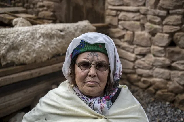 Khadra Kabssi, 74, a berber woman from the Chaouia region, who has facial tattoos, sits in her home in Chalma at the Aures Mountain near the eastern city of Batna, Algeria October 9, 2015. Among the Chaouia people of the Aures mountains, a woman's beauty used to be judged by her tattoos. (Photo by Zohra Bensemra/Reuters)
